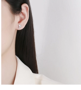 Close-up of cute silver koala stud earring worn on ear showing delicate details