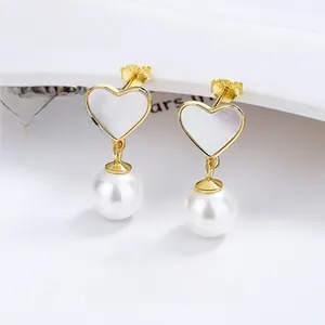 Detail of 925 silver heart stud earrings with white shell and round lustrous pearls