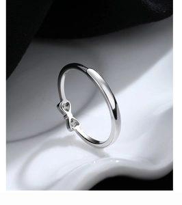 Macro shot of 925 sterling silver bow knot ring on white ceramic and black background