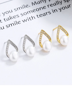 Gros plan de boucles d'oreilles V en argent S925 et or avec perles et zircons