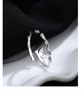 Detail of bamboo joint texture silver ring with a crystal butterfly on a wave base