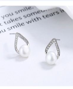Vue macro de boucles d'oreilles en argent avec perles en V et micro-pavé de zircon