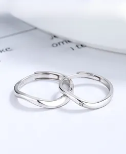 Dettaglio anello in argento con design a onde intrecciate e piccolo zircone brillante