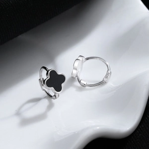 Vue macro de boucles d'oreilles trèfle en argent 925 avec incrustation noire et poinçon