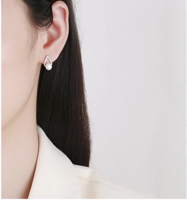 Gros plan de boucles d'oreilles perles en argent en forme de V avec zircons sur un modèle