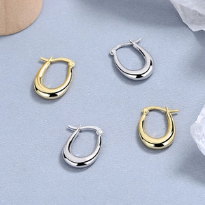 Nahaufnahme minimalistischer U-Ohrringe in Gold und Silber mit Spiegelglanz-Finish