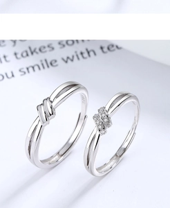 Detail of adjustable S925 sterling silver couple rings with knot design and zircon inlay