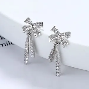Macro shot of 925 sterling silver bow earrings with sparkling tassel and CZ inlay