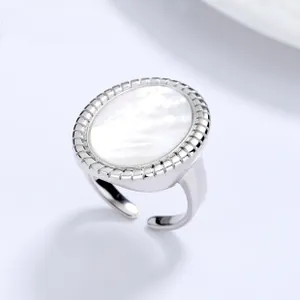 Macro shot of oval white shell inlay on 925 silver koi ring with textured bezel