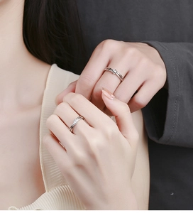 Close-up of 925 silver lovers knot rings with a single diamond inlay for couples