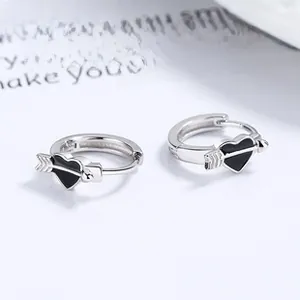 Makro-Detail von 925 Sterling Silber Creolen mit schwarzem Herz- und Pfeil-Design