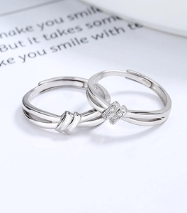 Macro shot of 925 silver love knot couple rings with sparkling zircon inlay details