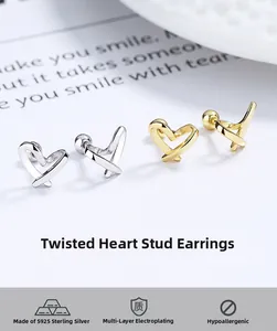 Detailed view of silver and gold S925 heart earrings with polished plated finish