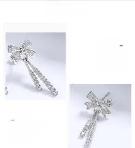 Detailed macro view of silver bow stud earrings with cubic zirconia micro-pave drops