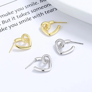 Détail des boucles d'oreilles cœur en argent sterling 925 en finitions or et argent