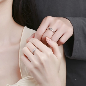 Pair of adjustable 925 sterling silver lover's knot rings worn by a couple