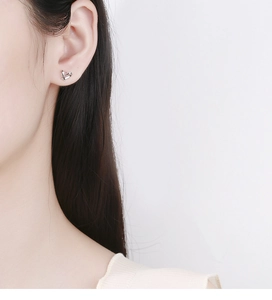 Close-up of minimalist 925 sterling silver hollow heart stud earring on model's ear