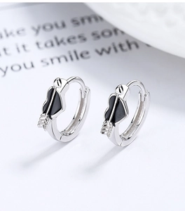 Dettaglio di orecchini a cuore in argento con smalto nero e freccia con piccoli zirconi