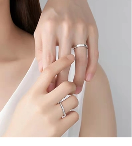 Detail of 925 silver couple rings with single diamond and pave-set stones on hands