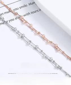 Detailed shot of double-layer silver and rose gold bead bracelets on decorative card