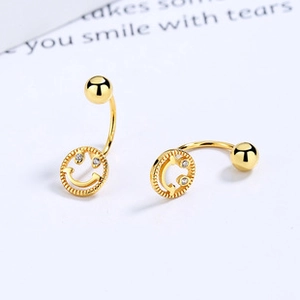 Macro shot of 18K gold smiley face earrings with sparkling zircon eyes and screw back closure