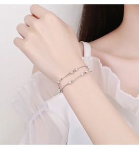 Detail of elegant double-layered 925 silver bead bracelet on woman's wrist