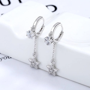 Macro view of 925 silver star earrings with zircon inlay and hollow star pendants