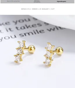 Gros plan détaillé de boucles d'oreilles en argent S925 doré avec trois zircons carrés