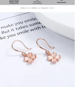 Vue macro des boucles d'oreilles trèfle en or rose avec pétales d'opale et zircons