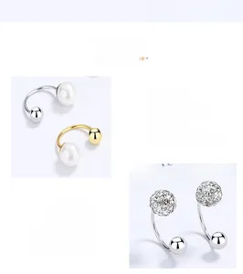 Detailed macro view of S925 silver C-shape stud earrings with pearls and crystal balls
