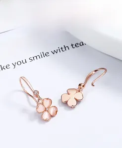 Détails des boucles d'oreilles trèfle en or rose avec pierre oeil de chat rose