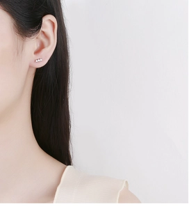 Détail d'une boucle d'oreille en argent 925 avec trois petits diamants sur l'oreille