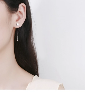 Close-up of 925 sterling silver four-leaf clover ear threader with long tassels