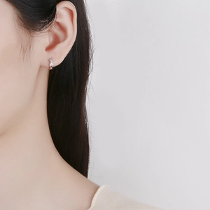 Elegant 925 sterling silver bow earrings with sparkling zirconia on a female model