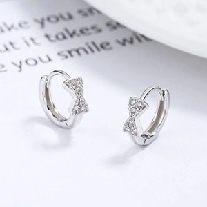 Polished 925 sterling silver bow earrings with sparkling zirconia in a diagonal view