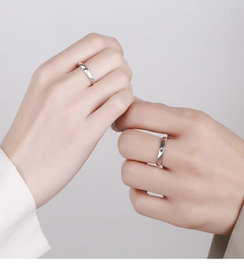 Close-up of 925 sterling silver couple rings with sun and moon minimalist engraving