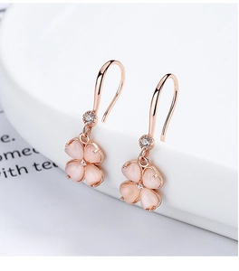 Vue détaillée des boucles d'oreilles trèfle en or rose et pierre œil-de-chat rose pastel