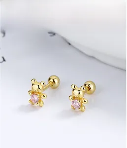 Macro shot of S925 sterling silver golden bear stud earrings with pink zircon stone