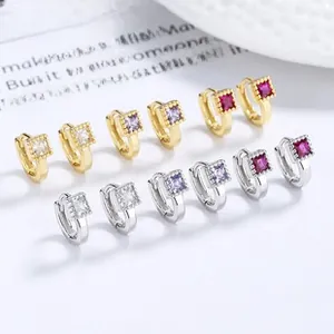 Detail of square zircon huggie earrings in gold and silver plating with bead edge