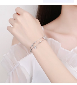 Close-up of elegant double-layered 925 sterling silver bracelet with maple leaf pendant