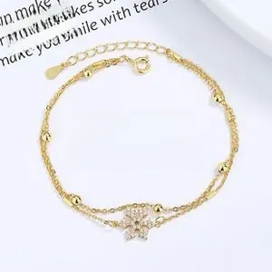 Close-up of a double-layered gold snowflake bracelet with micro-paved cubic zirconia gems