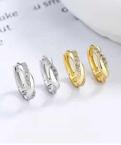 Makroaufnahme gedrehter 925er Silber-Ohrringe mit Zirkon-Pavé in Gold und Silber