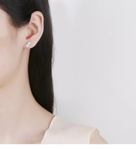 Detail of 925 silver gourd stud earrings with pavé crystals shown on model's ear
