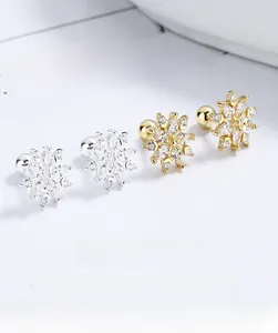 Macro shot of 925 sterling silver snowflake stud earrings with screw backs in gold and silver