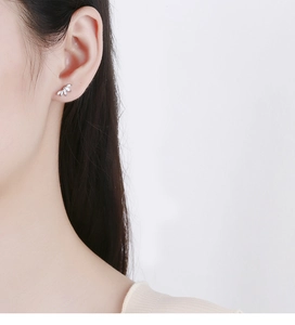 Close-up of 925 sterling silver marquise stud earring with white zircons on female ear