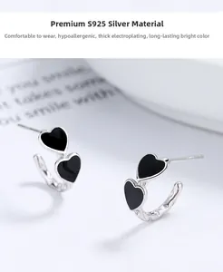 Detail view of S925 silver C-shape earrings with black enamel double heart design