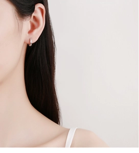 Nahaufnahme von 925 Sterling Silber Creolen mit Seildesign am Ohr des Models