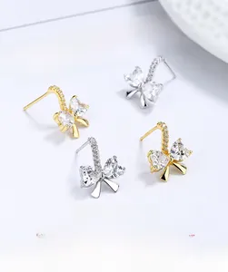 Détail de boucles d'oreilles nœud en argent S925 avec zircons étincelants or et argent