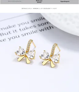 Détail macro de boucles d'oreilles en argent S925 avec zircons scintillants en cœur