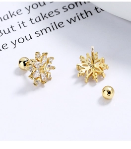 Macro shot of 925 sterling silver snowflake earrings with gold plating and screw backs